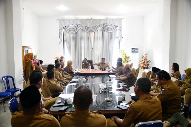 Foto 1: Bupati Oskar Manoppo bersama Wakil Bupati Argo V. Sumaiku memimpin rapat kerja dengan jajaran pimpinan SKPD di Pemerintah Kabupaten Boltim. Diskusi berlangsung serius di ruang rapat, dengan para peserta yang fokus mendengarkan arahan dari pimpinan daerah.