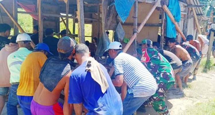 Bupati Boltim, Oskar Manopo (kaos putih bergaris hitam, topi putih), bersama warga dan relawan lainnya sedang mengangkat rumah yang terancam ambruk akibat pengikisan tebing sungai. Aksi gotong royong ini menggambarkan solidaritas masyarakat dalam menghadapi bencana banjir di Panang Desa Kotabunan.