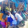 Bupati Boltim, Oskar Manopo (kaos putih bergaris hitam, topi putih), bersama warga dan relawan lainnya sedang mengangkat rumah yang terancam ambruk akibat pengikisan tebing sungai. Aksi gotong royong ini menggambarkan solidaritas masyarakat dalam menghadapi bencana banjir di Panang Desa Kotabunan.