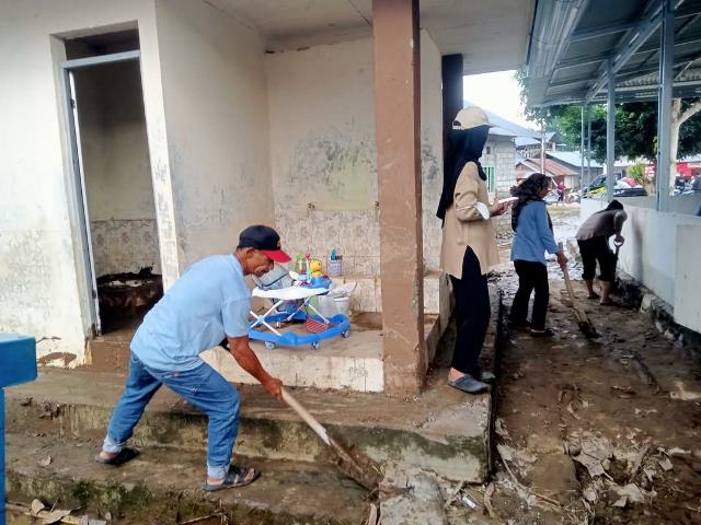 Relawan di Desa Togid sedang membersihkan area sekitar fasilitas umum yang terdampak banjir. Kerja keras mereka menunjukkan komitmen untuk mempercepat pemulihan pasca bencana.