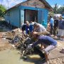 Aparat Desa Tutuyan mengangkut sampah dan lumpur dari area terdampak banjir. Gotong royong dilakukan bersama warga.
