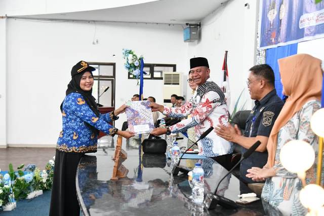 Bupati Bolaang Mongondow Timur, Oskar Manoppo, S.E., M.M, menyerahkan secara simbolis SK CPNS kepada salah satu peserta yang mengenakan seragam Korpri dalam kegiatan yang digelar di Aula Kantor Bupati, Kamis, (22/5/2025).