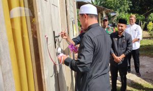 Bupati Bolmut Sirajudin Lasena didampingi Wakil Bupati Moh. Aditya Pontoh melakukan penyerahan simbolis kunci rumah layak huni kepada warga Desa Tuntung dengan memotong pita di depan rumah baru yang telah selesai dibangun. Prosesi ini merupakan bagian dari program rehabilitasi Rumah Tidak Layak Huni (RTLH) yang bertujuan meningkatkan kualitas hidup masyarakat.