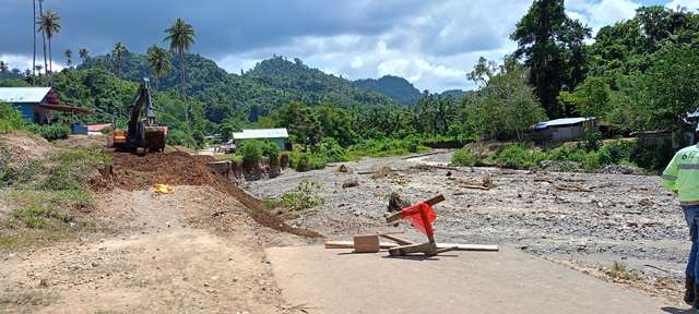 Proses perbaikan jalan yang putus akibat banjir di Desa Kotabunan. Pekerja konstruksi sedang mempersiapkan jalur alternatif untuk memastikan mobilitas warga tetap terjaga meskipun jalur utama terputus.