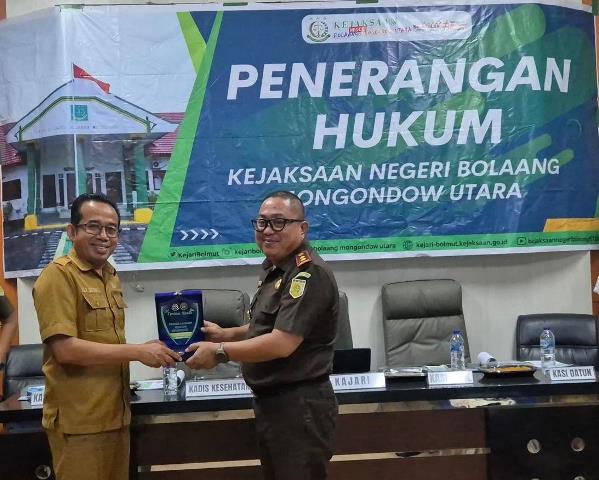 Kajari Boltara menyerahkan plakat kepada perwakilan Dinas Kesehatan usai kegiatan penerangan hukum di Aula Dinkes Bolmong Utara.