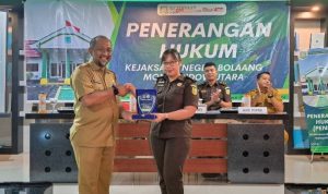 Kepala Dinas Pendidikan dan Kebudayaan Kabupaten Bolaang Mongondow Utara menyerahkan plakat penghargaan kepada Plt. Kasi Intel Kejaksaan Negeri Bolmut dalam acara Penerangan Hukum, Selasa (27/5/2025).
