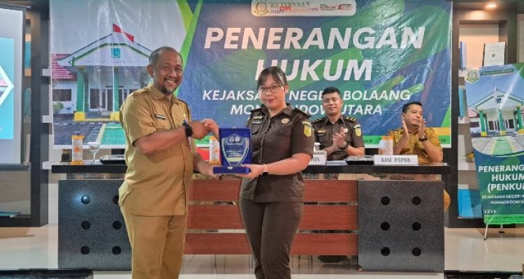 Kepala Dinas Pendidikan dan Kebudayaan Kabupaten Bolaang Mongondow Utara menyerahkan plakat penghargaan kepada Plt. Kasi Intel Kejaksaan Negeri Bolmut dalam acara Penerangan Hukum, Selasa (27/5/2025).