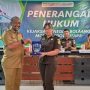 Kepala Dinas Pendidikan dan Kebudayaan Kabupaten Bolaang Mongondow Utara menyerahkan plakat penghargaan kepada Plt. Kasi Intel Kejaksaan Negeri Bolmut dalam acara Penerangan Hukum, Selasa (27/5/2025).