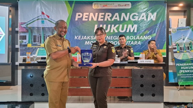 Kepala Dinas Pendidikan dan Kebudayaan Kabupaten Bolaang Mongondow Utara menyerahkan plakat penghargaan kepada Plt. Kasi Intel Kejaksaan Negeri Bolmut dalam acara Penerangan Hukum, Selasa (27/5/2025).