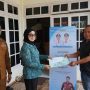 Ketua TP PKK Boltim menyerahkan bantuan skepada warga terdampak Banjir.