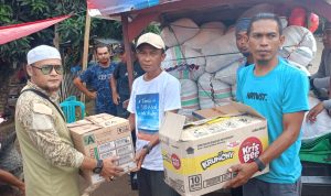 Komarudin Butiti menyerahkan bantuan kemanusiaan dari warga Desa Bentenan kepada warga korban banjir di Desa Togid, Boltim