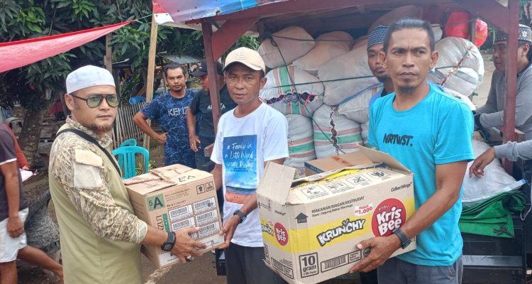 Komarudin Butiti menyerahkan bantuan kemanusiaan dari warga Desa Bentenan kepada warga korban banjir di Desa Togid, Boltim