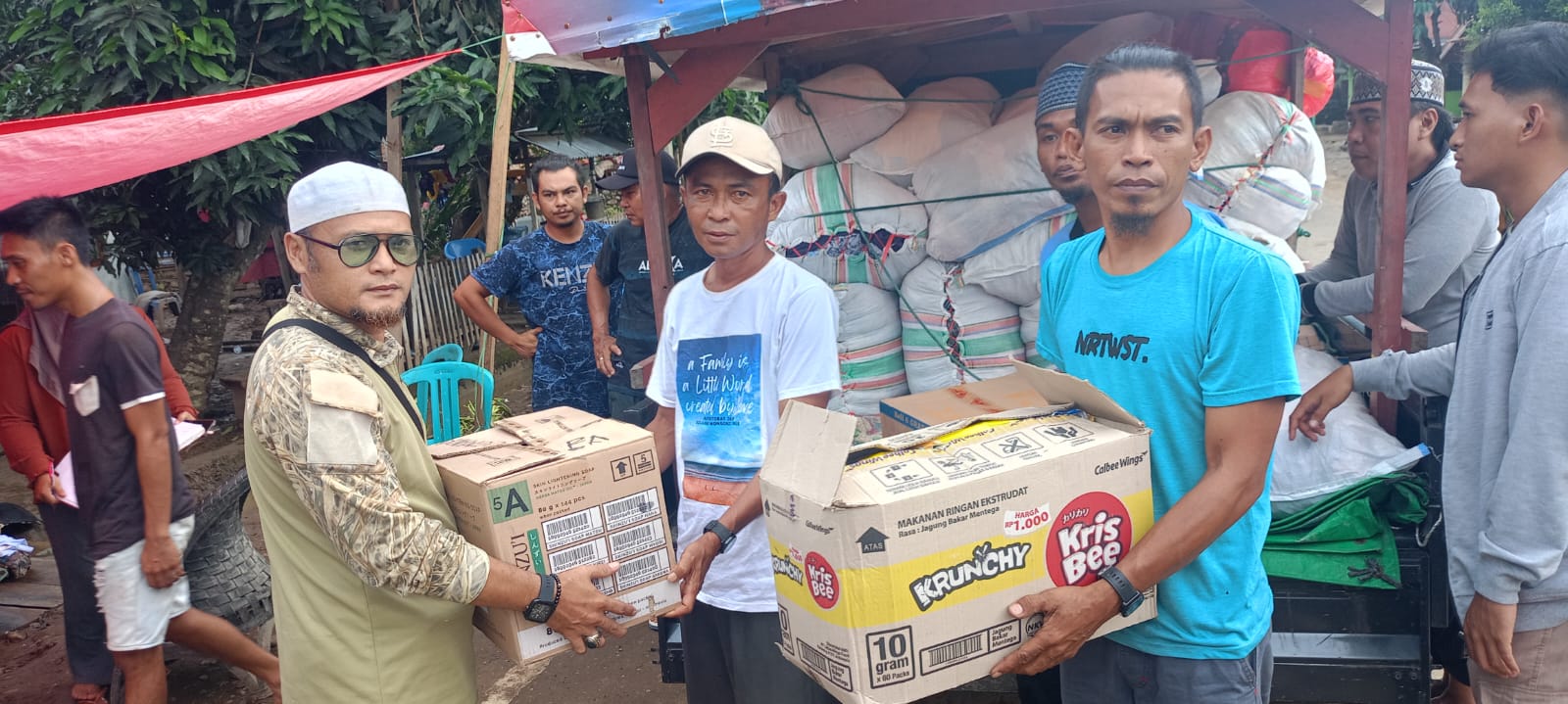 Komarudin Butiti menyerahkan bantuan kemanusiaan dari warga Desa Bentenan kepada warga korban banjir di Desa Togid, Boltim