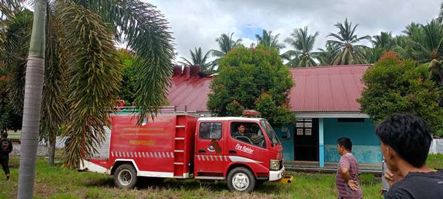 Petugas Damkar dan warga memadamkan api di laboratorium SMPN 2 Tutuyan