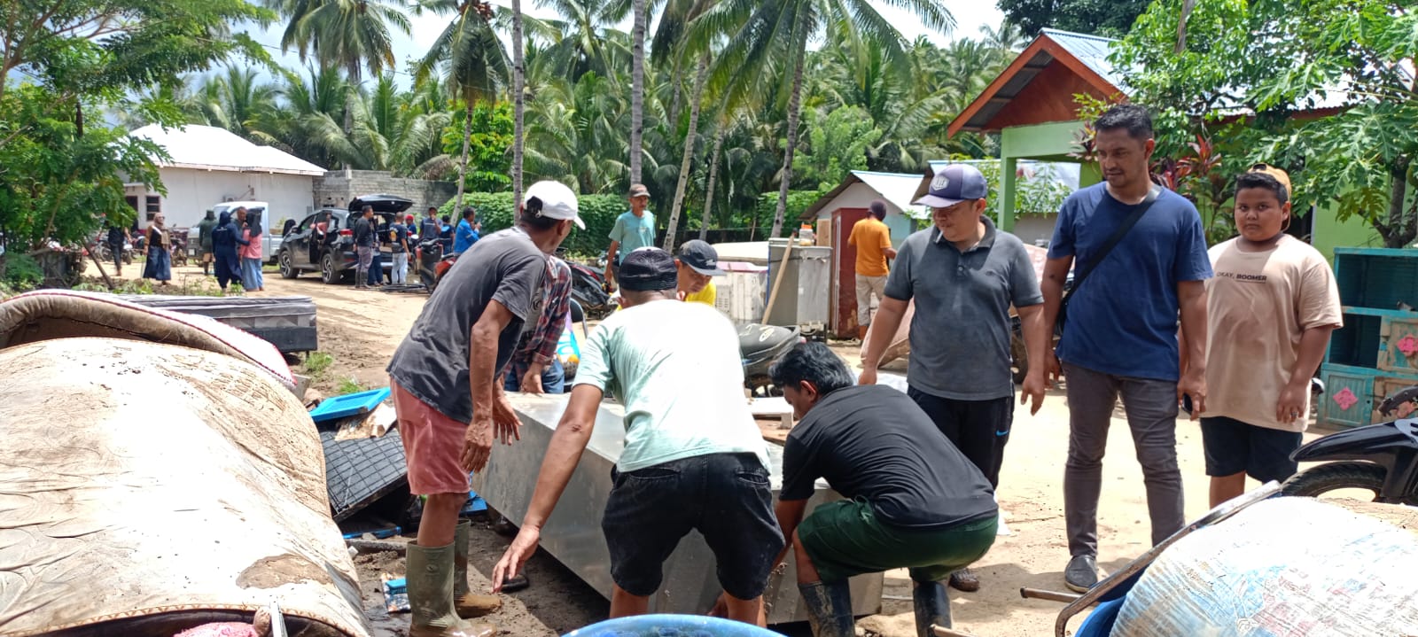 Wartawan BINADOW membantu warga membersihkan rumah pasca banjir di Desa Togid