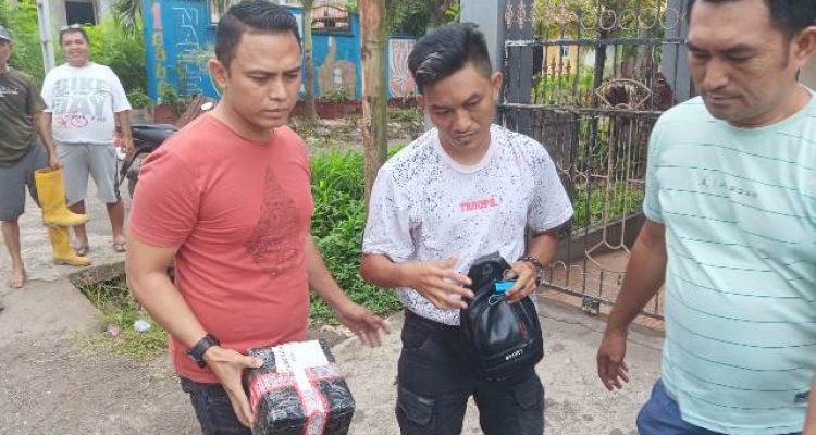 Kasat Resnarkoba IPTU Trivo Datukramat (kiri) bersama tim mengamankan pelaku dan barang bukti usai pengambilan paket kiriman di wilayah Girian Permai.