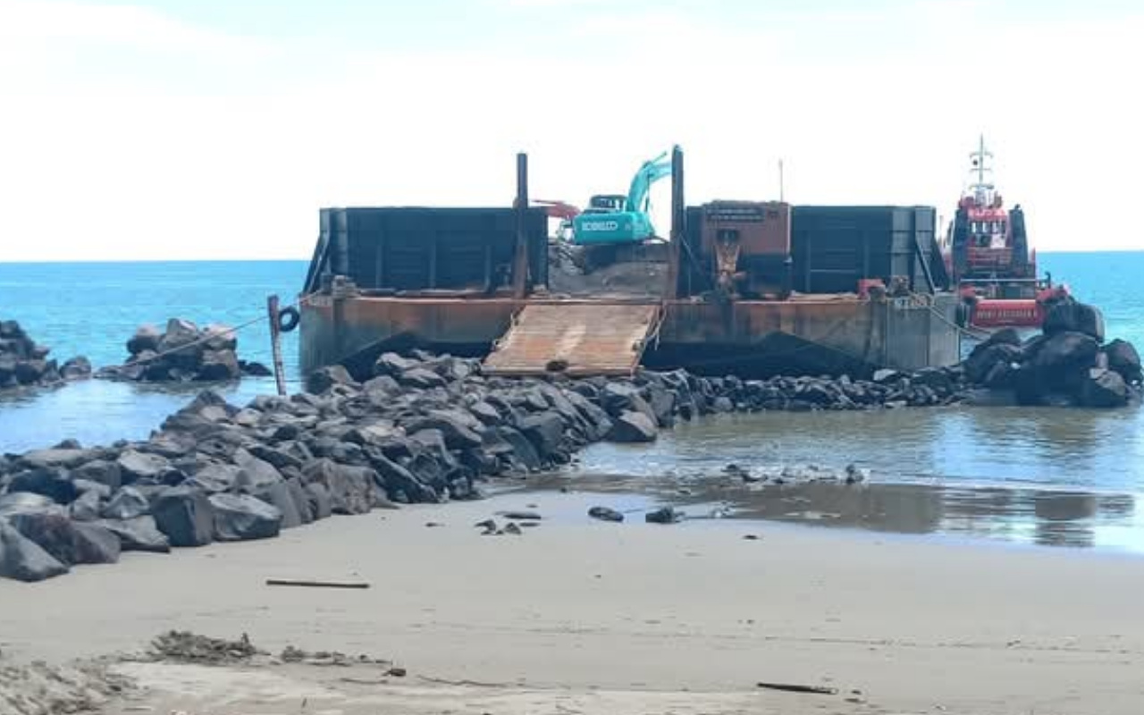 Pemerintah Kabupaten Bolaang Mongondow Utara menagih pajak mineral bukan logam dan batu dari kontraktor proyek APBN di Batu Pinagut. Namun, kontraktor mempertanyakan dasar hukum kebijakan itu karena material diperoleh dari penambang lokal yang belum berizin. Kebijakan ini dinilai tidak konsisten.