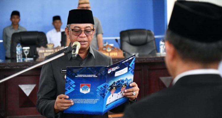 Bupati Oskar Manoppo membacakan naskah pelantikan Penjabat Sekda Kabupaten Boltim, Moh. Iksan Pangalima, dalam acara resmi di Aula Kantor Bupati.