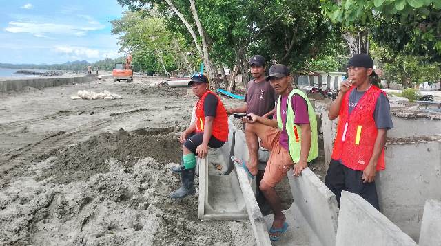Sejumlah pekerja proyek pengaman pantai Batu Pinagut, Kecamatan Kaidipang, saat beristirahat di lokasi pekerjaan. Mereka mengaku sudah terdaftar dalam program BPJS Ketenagakerjaan.