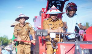 Bupati Bolaang Mongondow Utara Sirajudin Lasena (tengah) bersama Wakil Bupati Aditya Pontoh (kiri) mencoba langsung mesin panen padi Combine Harvester yang diserahkan kepada Kelompok Tani Tampo Damba III, di Desa Tuntulou Utara, Selasa (5/8/2025).