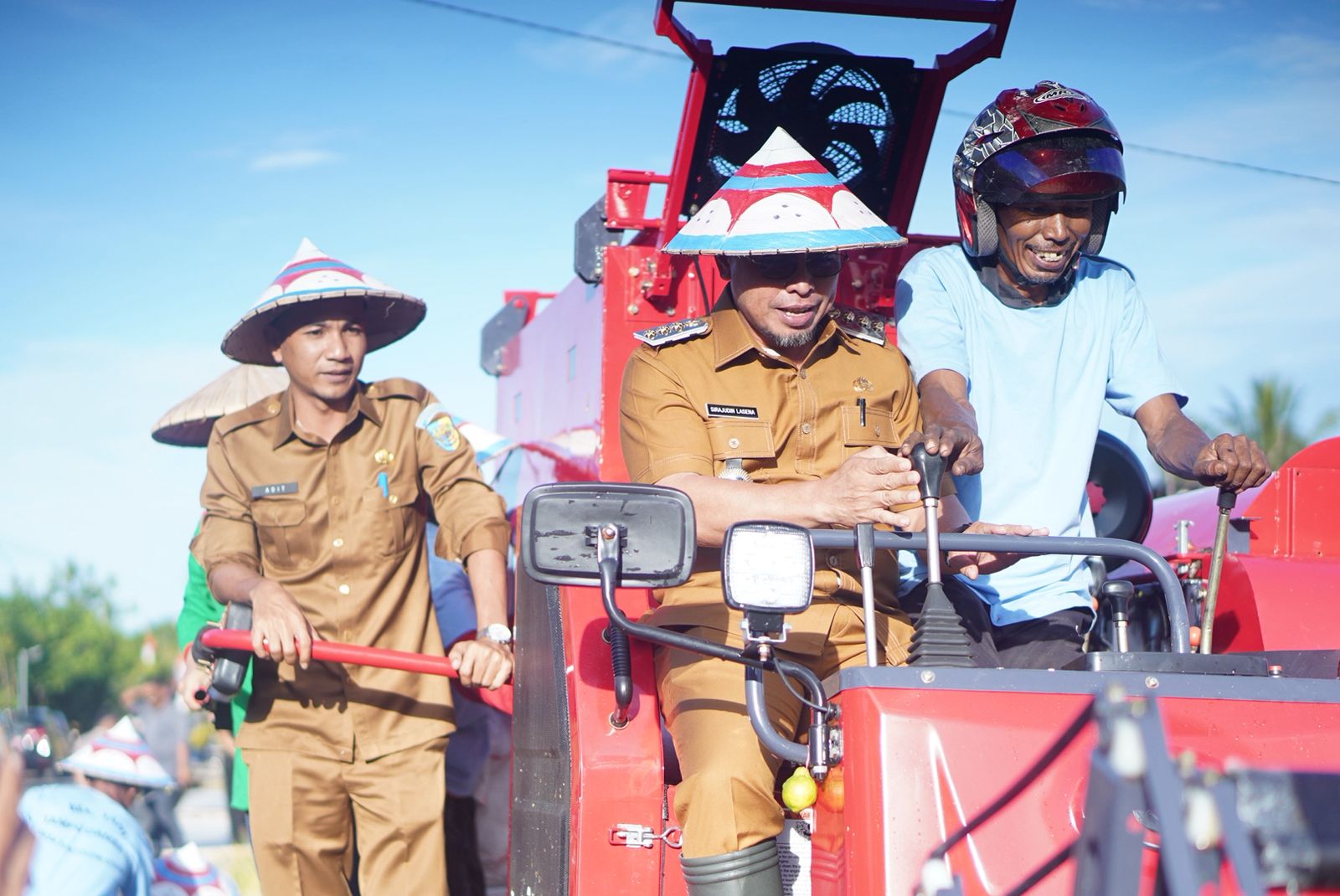 Bupati Bolaang Mongondow Utara Sirajudin Lasena (tengah) bersama Wakil Bupati Aditya Pontoh (kiri) mencoba langsung mesin panen padi Combine Harvester yang diserahkan kepada Kelompok Tani Tampo Damba III, di Desa Tuntulou Utara, Selasa (5/8/2025).