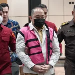 Tersangka kasus TPPU Sritex mengenakan rompi tahanan pink dikawal petugas Kejaksaan saat berjalan di dalam gedung.