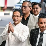 Nadiem Makarim mengenakan kemeja putih bersama Hotman Paris berjalan menuju Kejaksaan Agung terkait pemeriksaan kasus Chromebook.
