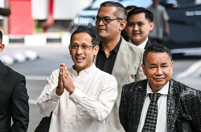 Nadiem Makarim mengenakan kemeja putih bersama Hotman Paris berjalan menuju Kejaksaan Agung terkait pemeriksaan kasus Chromebook.