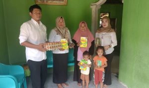 Plt. Kepala Dinas Ketahanan Pangan Bolaang Mongondow Utara, Yulin Kohongia, SE, didampingi petugas saat menyerahkan bantuan pangan bergizi kepada keluarga penerima balita stunting di salah satu desa, Rabu (10/9/2025).