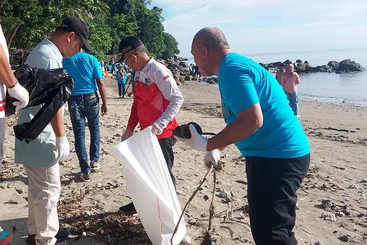 Warga bersama relawan membersihkan sampah yang menumpuk di sela-sela batu pesisir Pantai Batu Pinagut.