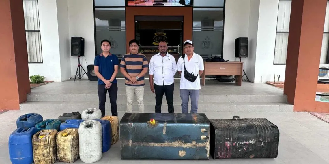 Sejumlah personel Polres Boltara memperlihatkan barang bukti hasil pengungkapan kasus penyalahgunaan solar subsidi di SPBU Boroko. Tampak galon-galon solar dan dua tangki besi besar yang diamankan dari lokasi penggerebekan.