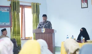 Asisten Administrasi Umum Boltara Abdul Nazarudin Maloho berdiri di podium menyampaikan sambutan pada pembukaan Program Pelatihan Mahasiswa Berdampak UDK 2025 di Desa Bigo Selatan.