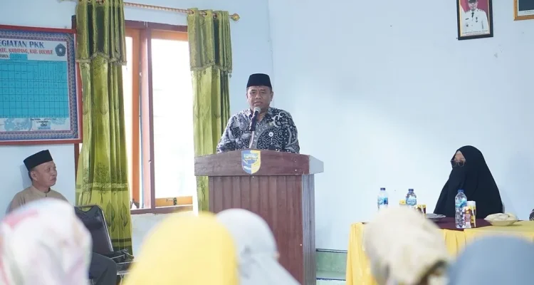 Asisten Administrasi Umum Boltara Abdul Nazarudin Maloho berdiri di podium menyampaikan sambutan pada pembukaan Program Pelatihan Mahasiswa Berdampak UDK 2025 di Desa Bigo Selatan.