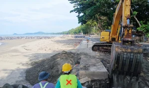 Pekerja proyek menggunakan alat berat menata struktur pengaman abrasi di Pantai Batu Pinagut, Bolaang Mongondow Utara.