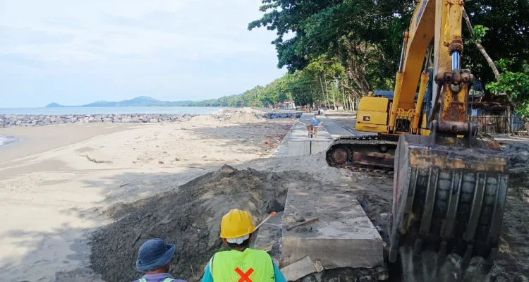 Pekerja proyek menggunakan alat berat menata struktur pengaman abrasi di Pantai Batu Pinagut, Bolaang Mongondow Utara.