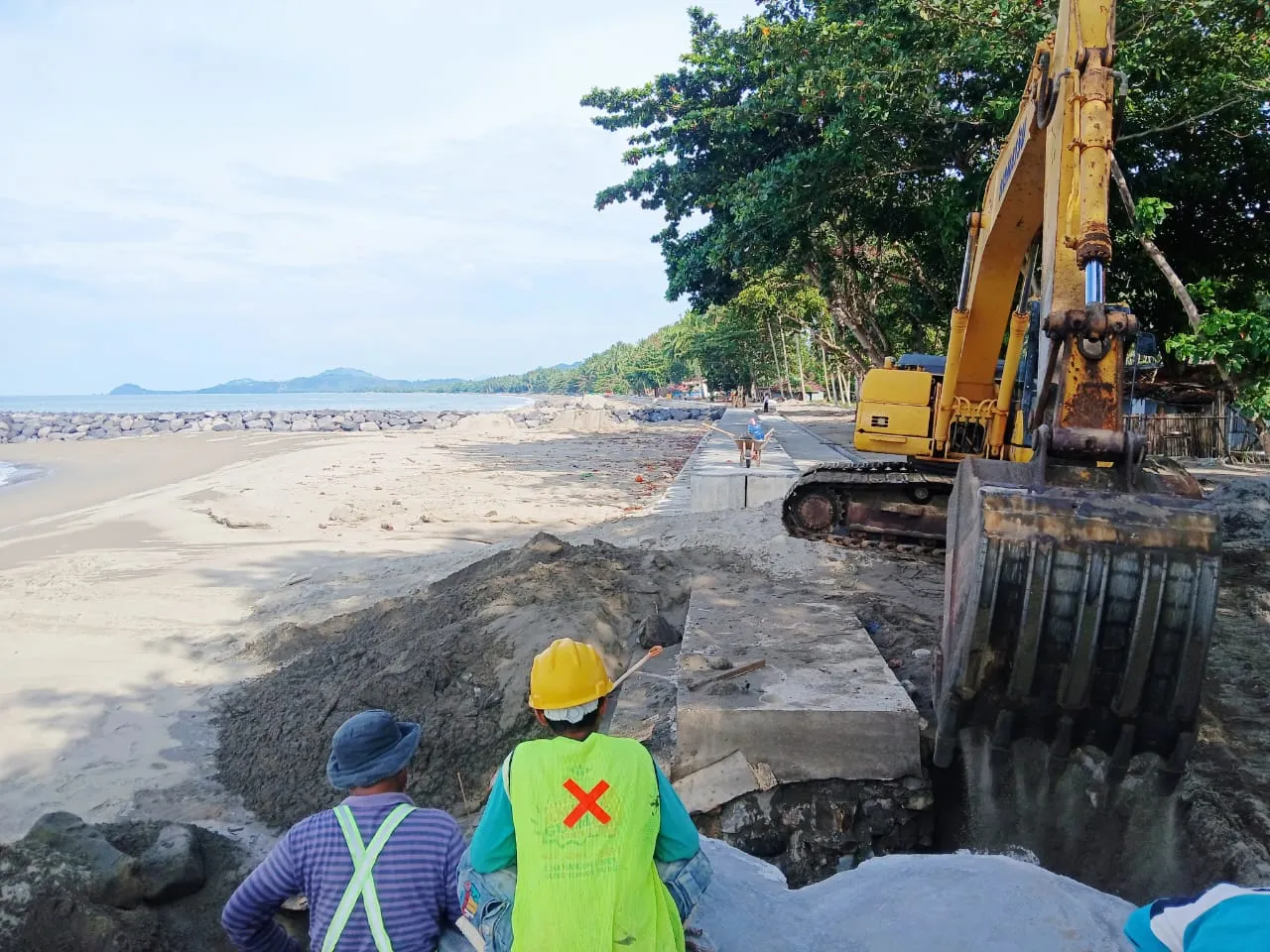 Pekerja proyek menggunakan alat berat menata struktur pengaman abrasi di Pantai Batu Pinagut, Bolaang Mongondow Utara.
