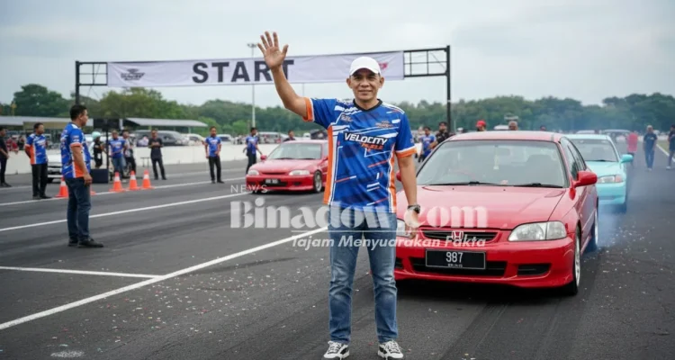 Ketua Panitia Kejurda Drag Race dan Drag Bike Piala Bupati Boltara 2025, Subhan Hasan, melambaikan tangan di garis start lintasan Jl. WR Supratman, Boroko Timur, sebelum dimulainya sesi latihan resmi.