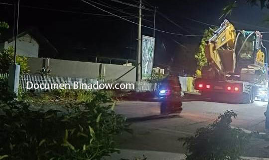 Ekskavator diangkut truk trailer melintas menuju Busato pada malam hari, diduga terkait aktivitas tambang ilegal di hulu Sungai Busato.