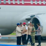 Presiden tiba di bandara Aceh dan berjabat tangan dengan pejabat daerah saat turun dari pesawat sebelum peninjauan lokasi banjir.