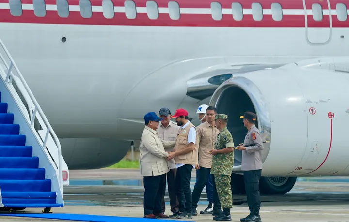 Presiden tiba di bandara Aceh dan berjabat tangan dengan pejabat daerah saat turun dari pesawat sebelum peninjauan lokasi banjir.
