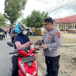 Kapolres Bolmong Utara memberikan paket takjil kepada pengendara motor di tepi Jalan Trans Sulawesi saat Ramadan.