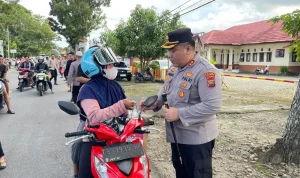 Kapolres Bolmong Utara memberikan paket takjil kepada pengendara motor di tepi Jalan Trans Sulawesi saat Ramadan.