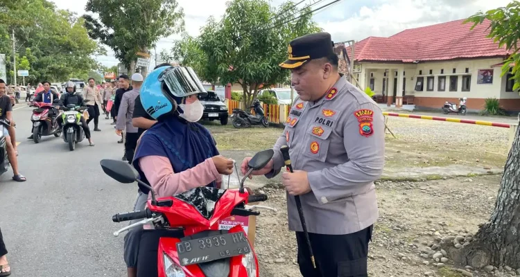 Kapolres Bolmong Utara memberikan paket takjil kepada pengendara motor di tepi Jalan Trans Sulawesi saat Ramadan.