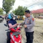 Kapolres Bolmong Utara memberikan paket takjil kepada pengendara motor di tepi Jalan Trans Sulawesi saat Ramadan.