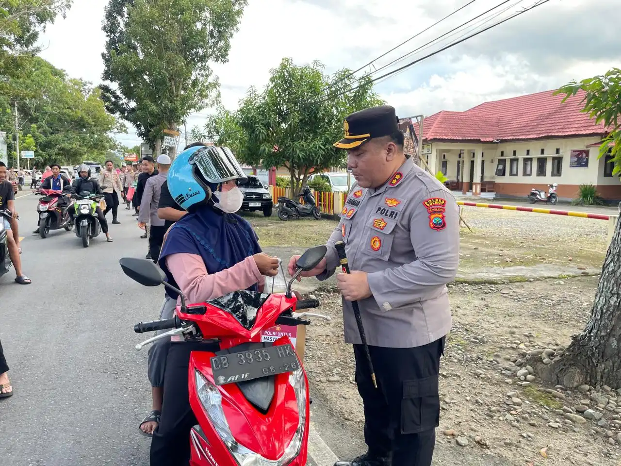 Kapolres Bolmong Utara memberikan paket takjil kepada pengendara motor di tepi Jalan Trans Sulawesi saat Ramadan.