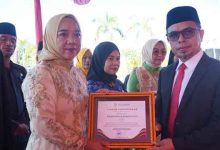 Bupati Bolmut Sirajudin Lasena menyerahkan piagam penghargaan kepada Kadis P3A Yani Lasama pada upacara Hari Kartini dan apel Korpri di halaman Kantor Bupati Bolmut.