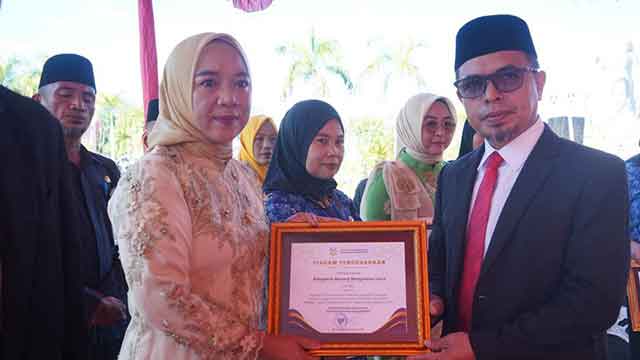 Bupati Bolmut Sirajudin Lasena menyerahkan piagam penghargaan kepada Kadis P3A Yani Lasama pada upacara Hari Kartini dan apel Korpri di halaman Kantor Bupati Bolmut.