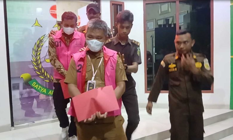 Foto: Kepala Desa Huntuk, Oldi F. Kumolontang (depan), bersama operator desa, Fadlan Alamri (belakang), mengenakan rompi tahanan usai ditetapkan sebagai tersangka dugaan korupsi Dana Desa dan Alokasi Dana Desa Tahun Anggaran 2024 oleh Kejari Bolaang Mongondow Utara.