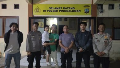 Personel Polsek Pinogaluman menunjukkan anak yang berhasil ditemukan dalam kondisi sehat, Minggu (5/7/2026) dini hari.