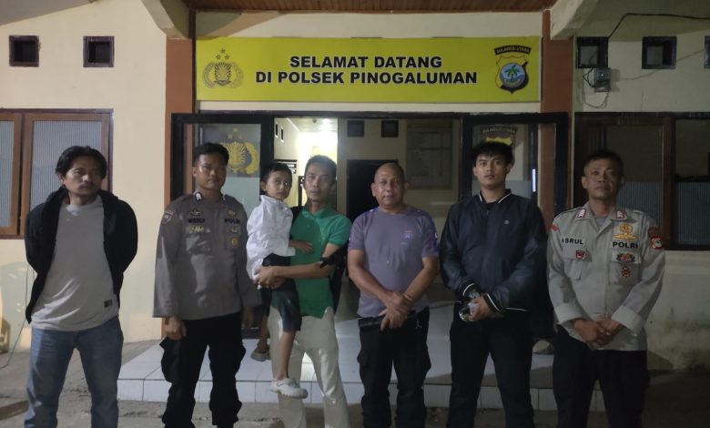 Personel Polsek Pinogaluman menunjukkan anak yang berhasil ditemukan dalam kondisi sehat, Minggu (5/7/2026) dini hari.